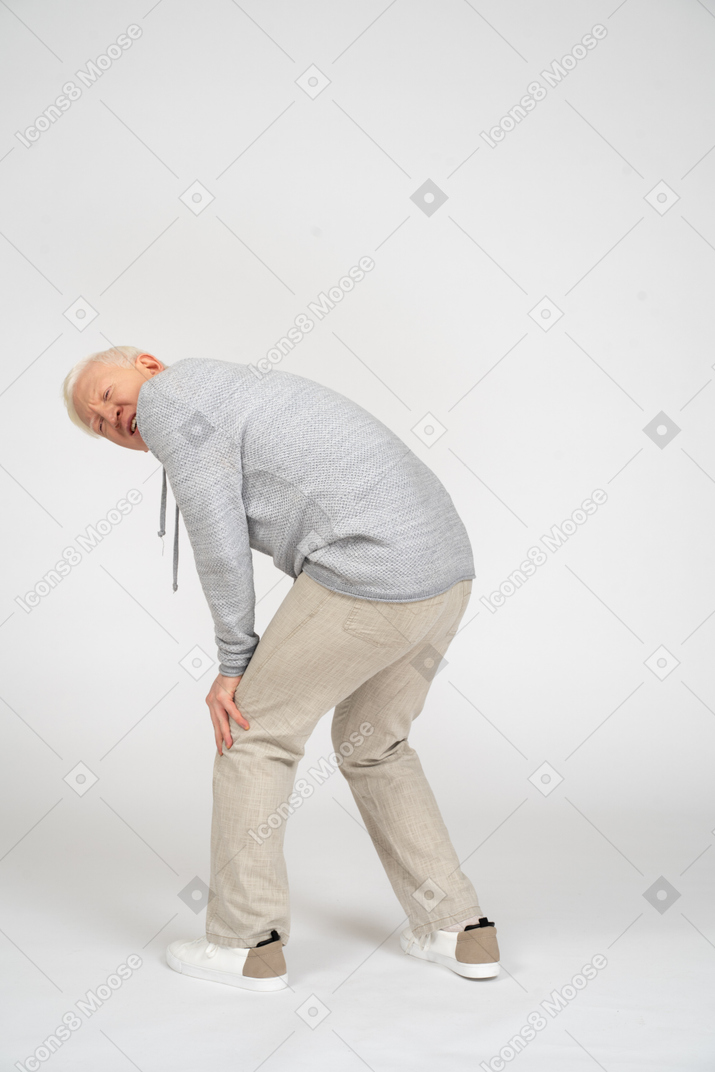 Огорченный мужчина с рукой на колене испытывает боль в колене