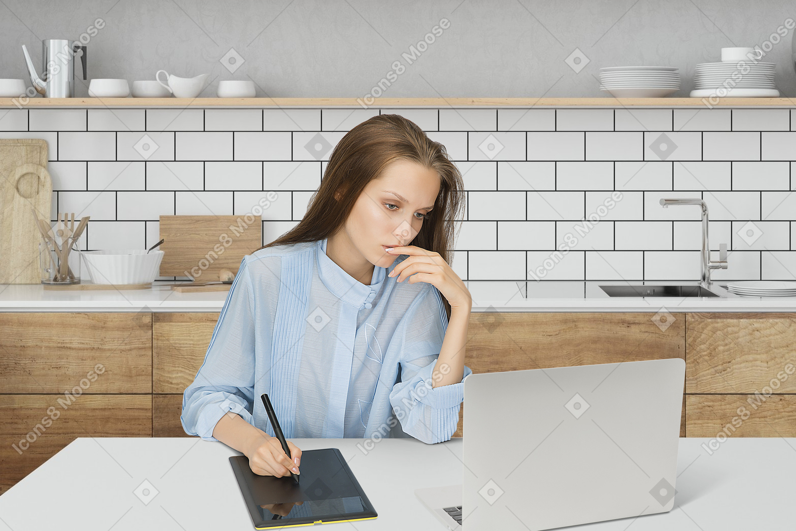 A woman sitting at a table using a laptop computer