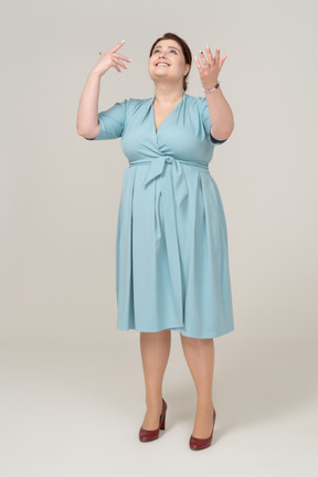Vista frontal de uma mulher de vestido azul olhando para cima