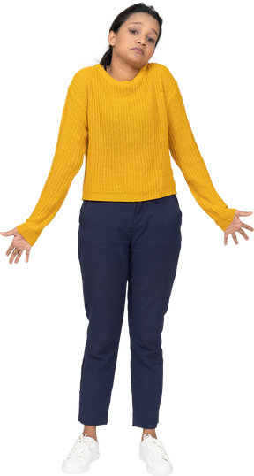 Front view of a cute girl in casual clothes standing with outstretched arms and looking at camera