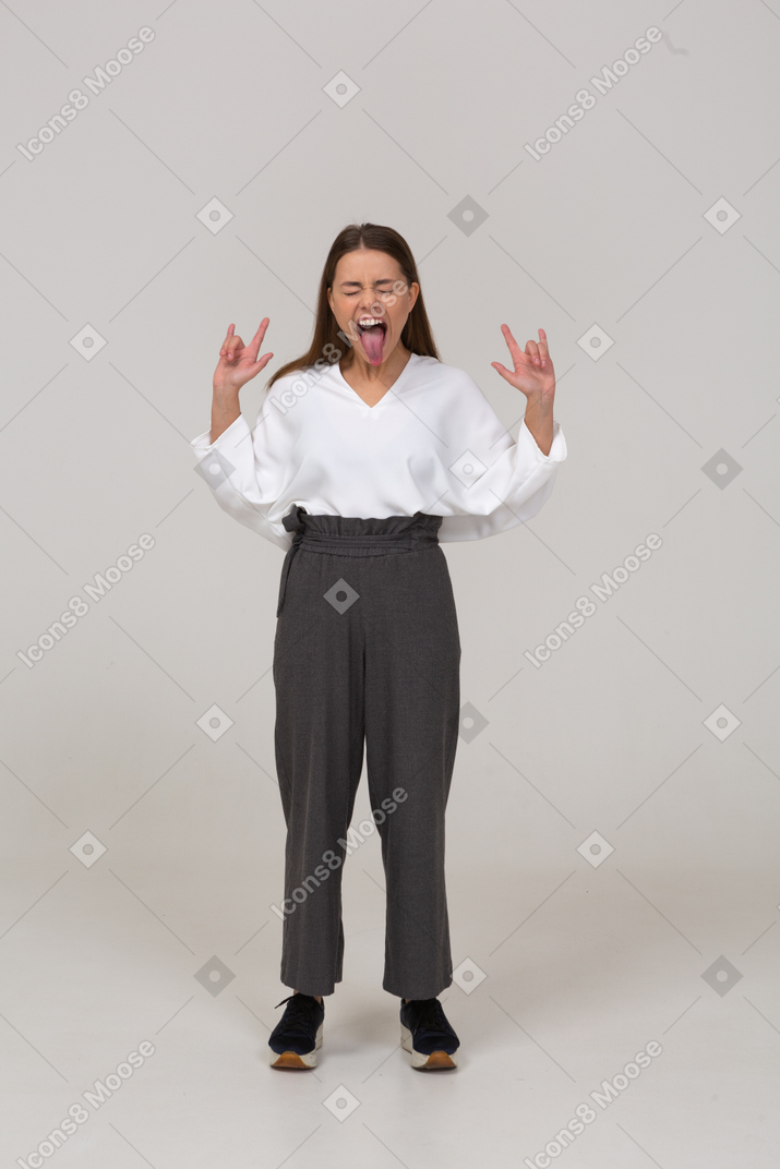 Front view of a screaming young female rocker in office clothing showing tongue