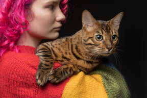 Eine bengalkatze auf der schulter ihres besitzers