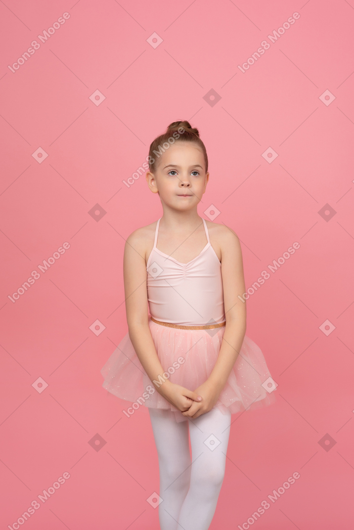 Cute little girl standing with her hands folded