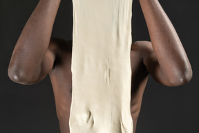 A young male hiding behind the dough in the dark