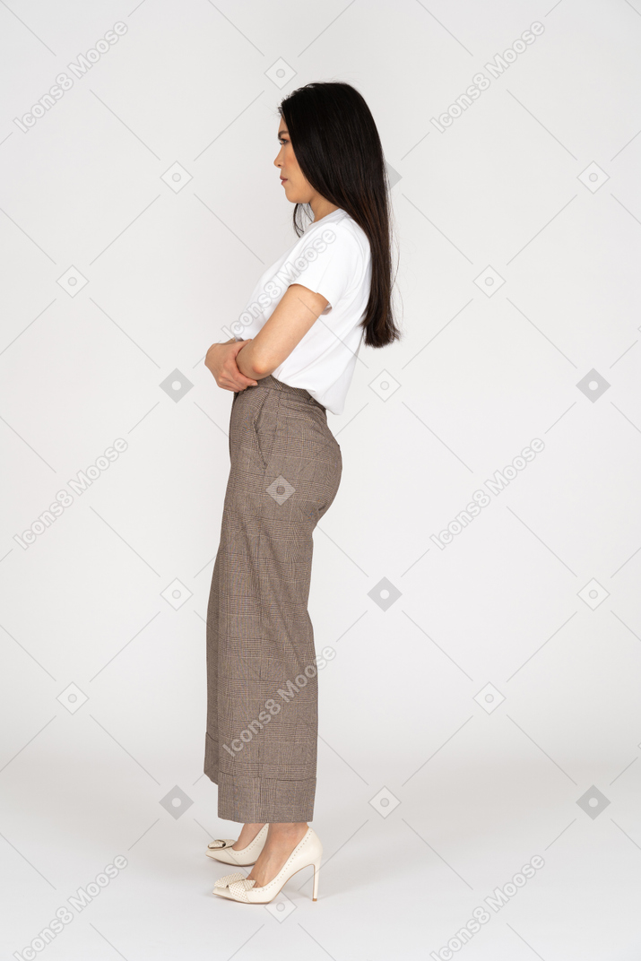 Vue latérale d'une jeune femme mécontente en culotte et t-shirt croisant les mains