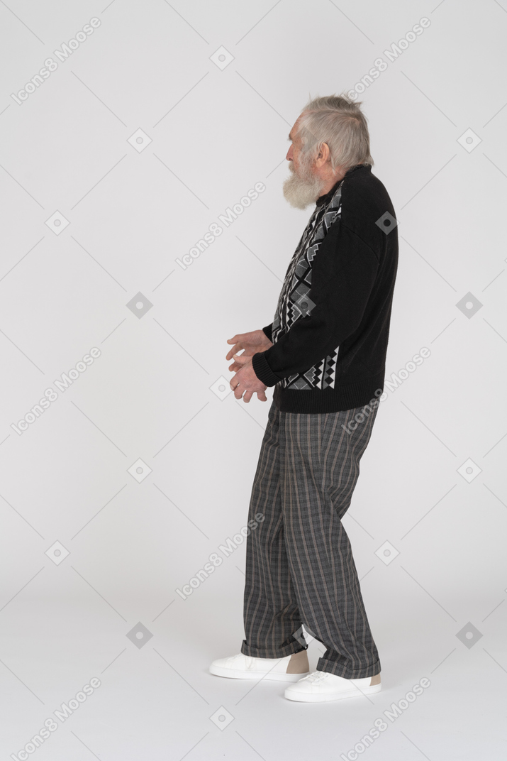 Vista laterale di un uomo anziano in possesso di qualcosa