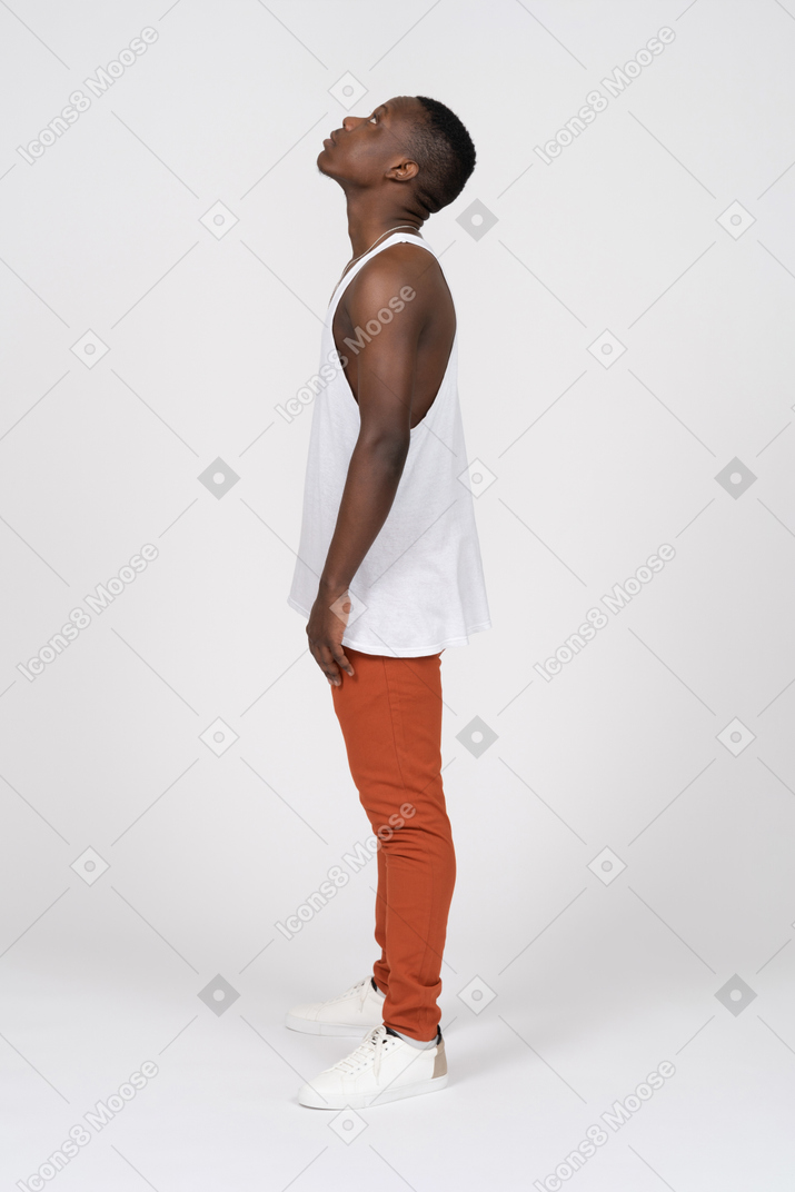 Side view of a man in tank top looking up