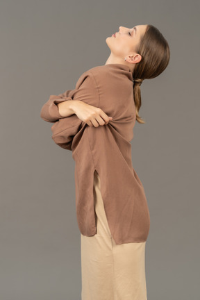 Side view of a woman with crossed arms talking her shirt off