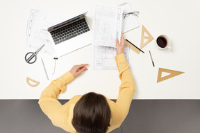 A female architect passing an architectural drawing