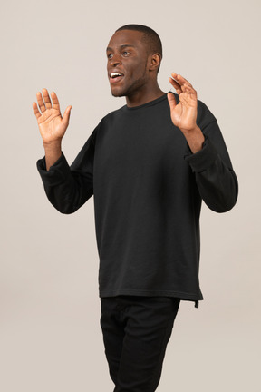 Excited young man raising his hands