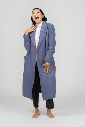 Mujer riendo con un abrigo azul