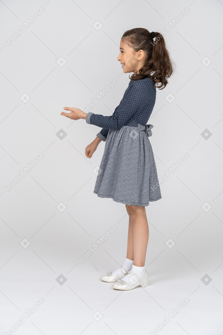 一个女孩困惑地笑着打手势的侧视图