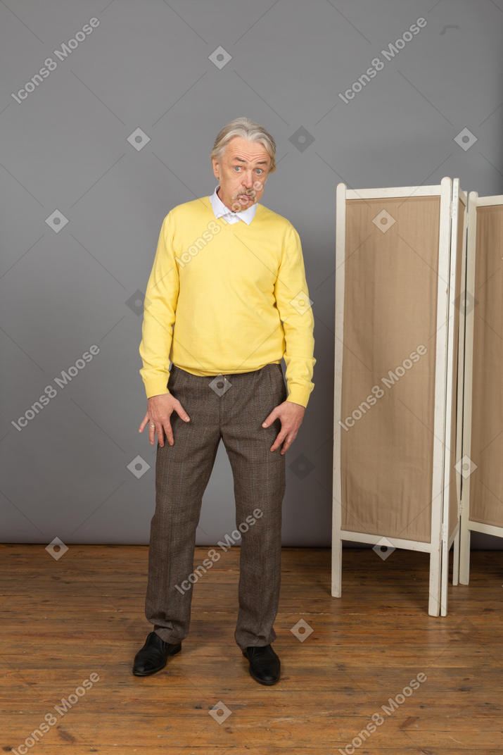 Front view of a disappointed old man blowing cheeks