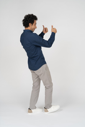 一个穿着休闲服的男人竖起大拇指的侧视图