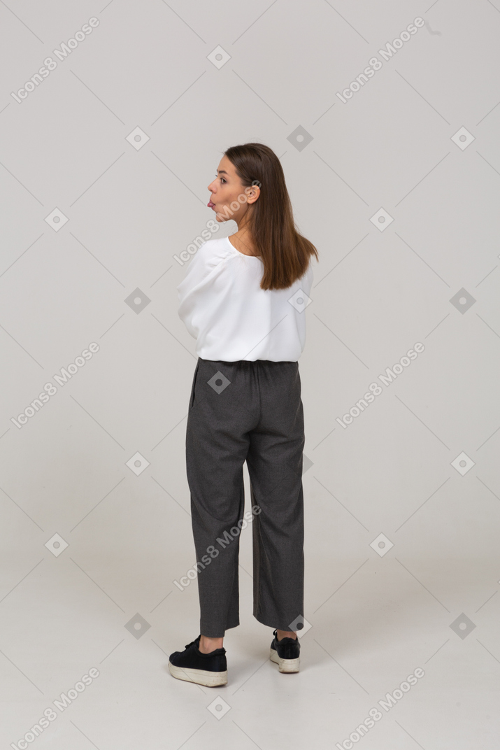 Back view of a young lady in office clothing showing tongue
