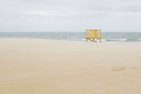 Bord de mer avec une cabane de plage jaune