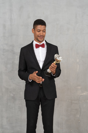 Smiling man in suit holding an award
