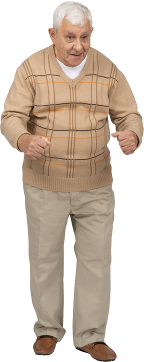 Front view of an old man in casual clothes standing with clenched fists