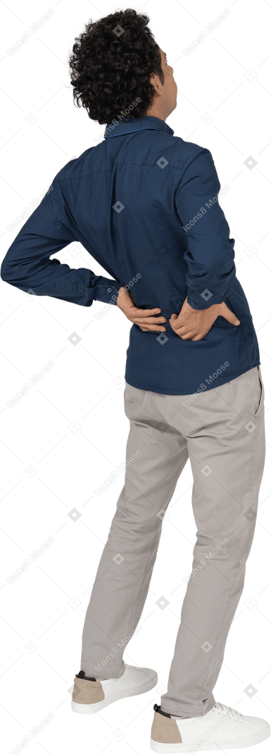 Rückansicht eines mannes in freizeitkleidung mit schmerzen im unteren rücken