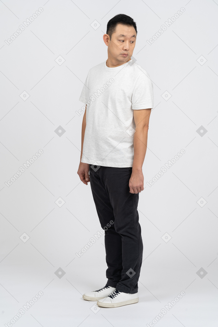 Man in casual clothes standing still and looking down