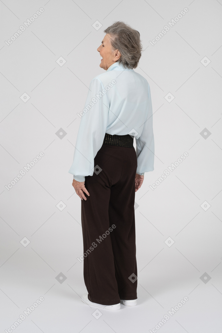 Rear view of an old woman laughing to the left
