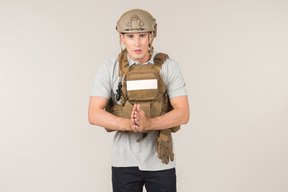 Male journalist in bulletproof vest standing with hands folded