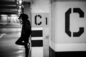 Jeune homme posant sur une place de parking