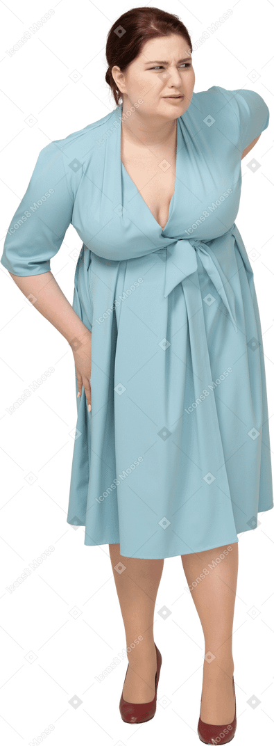 Front view of a woman in blue dress suffering from pain in lower back