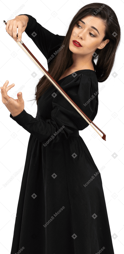 Vista de tres cuartos de una joven vestida de negro que da la impresión de tocar el violín