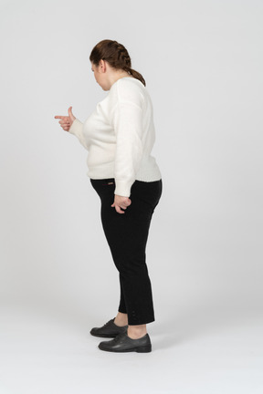 Side view of a plump woman pointing with a finger