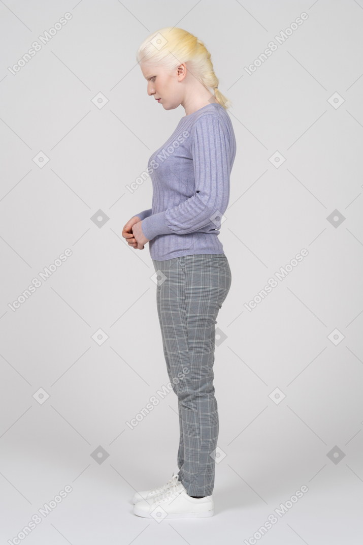 Vista lateral de uma mulher em pé com as mãos cruzadas