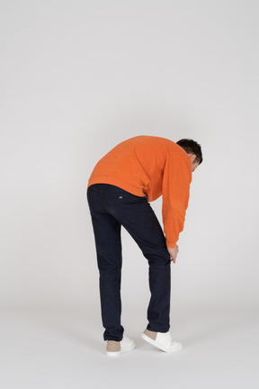 Young man in orange sweatshirt standing