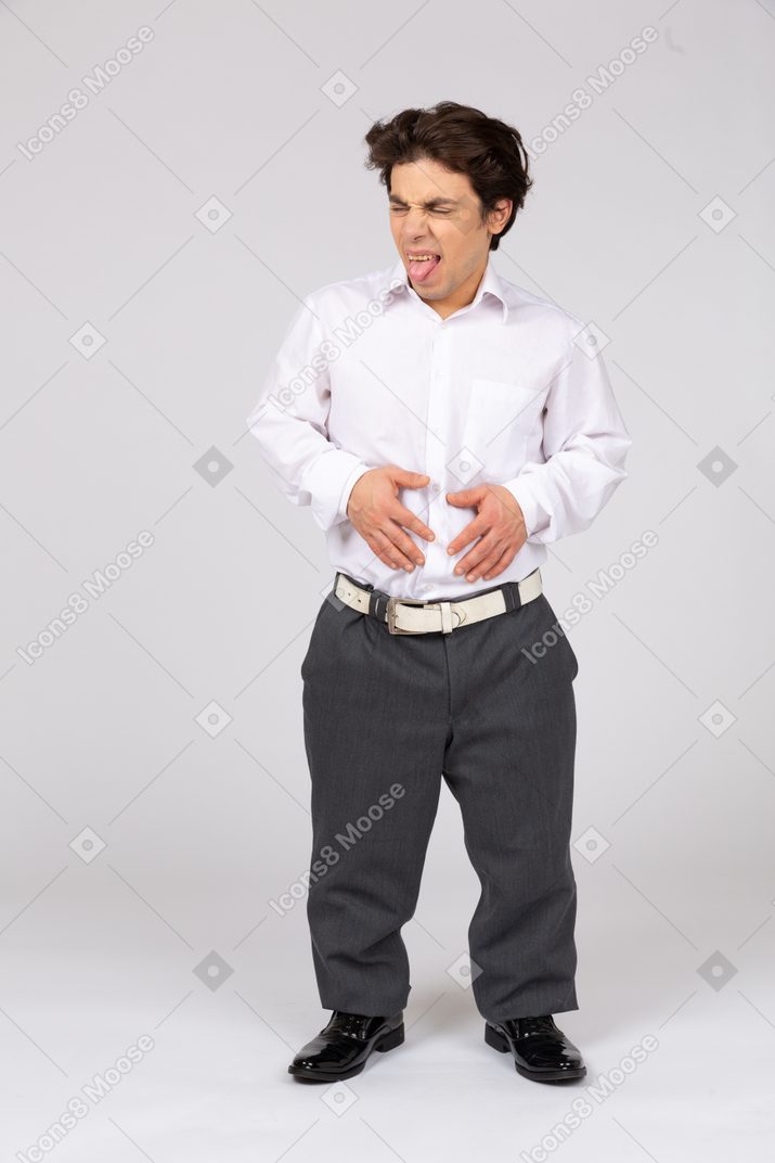 Hombre haciendo cara de disgusto y sosteniendo sus manos en el estómago