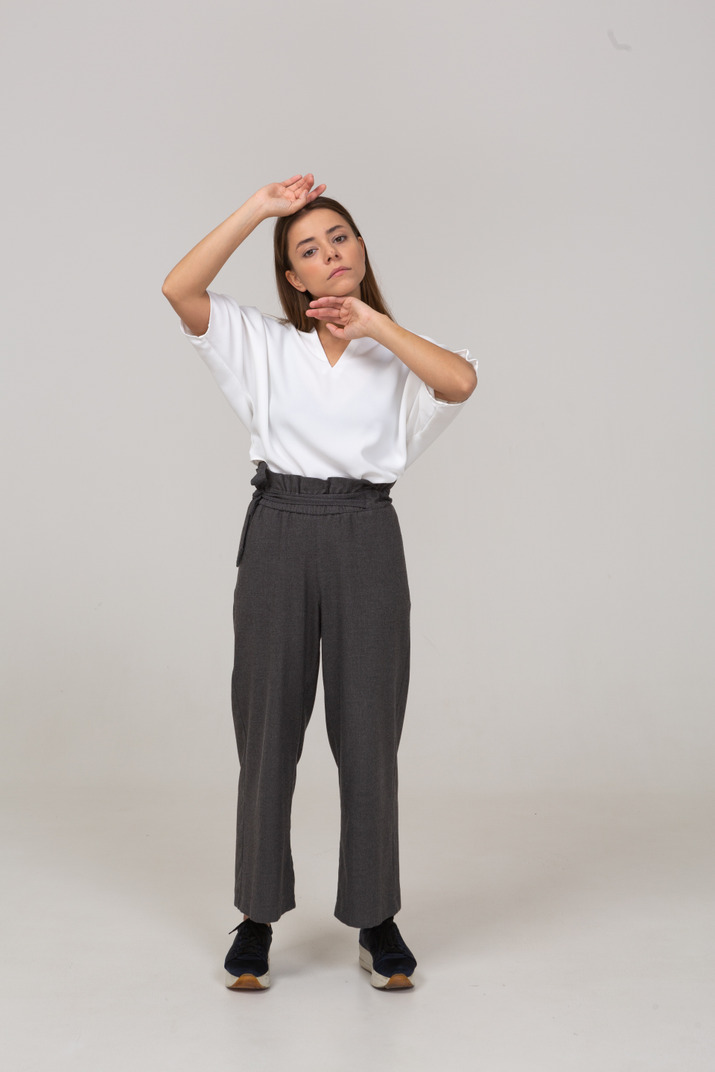 Front view of a young lady in office clothing touching her face