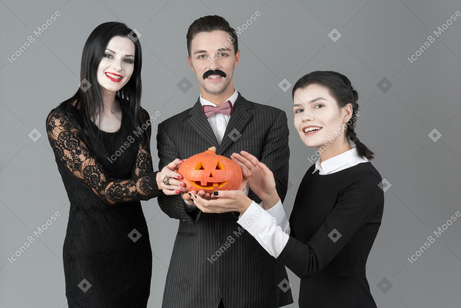 Addams family holding carved pumpkin