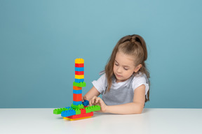 A little girl playing with building blocks