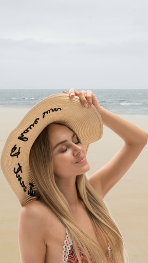 A woman wearing a hat on the beach