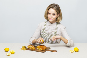 Menina sentada à mesa e cozinhar uma torta de limão