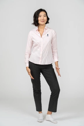 Happy woman in office clothing posing with arms at sides