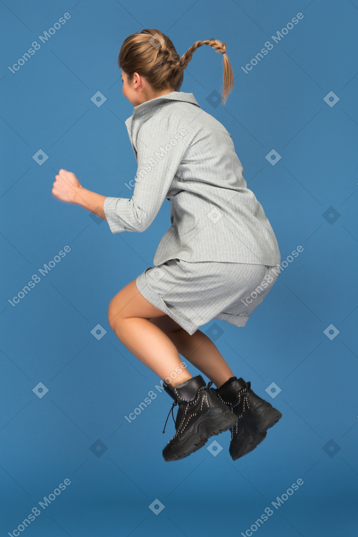 Молодая женщина прыгает вверх