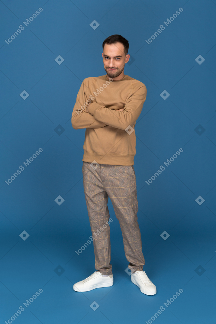 Angry young man standing with hands crossed