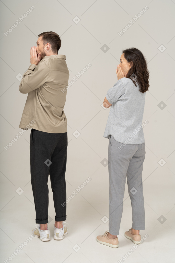 Three-quarter back view of amazed young couple