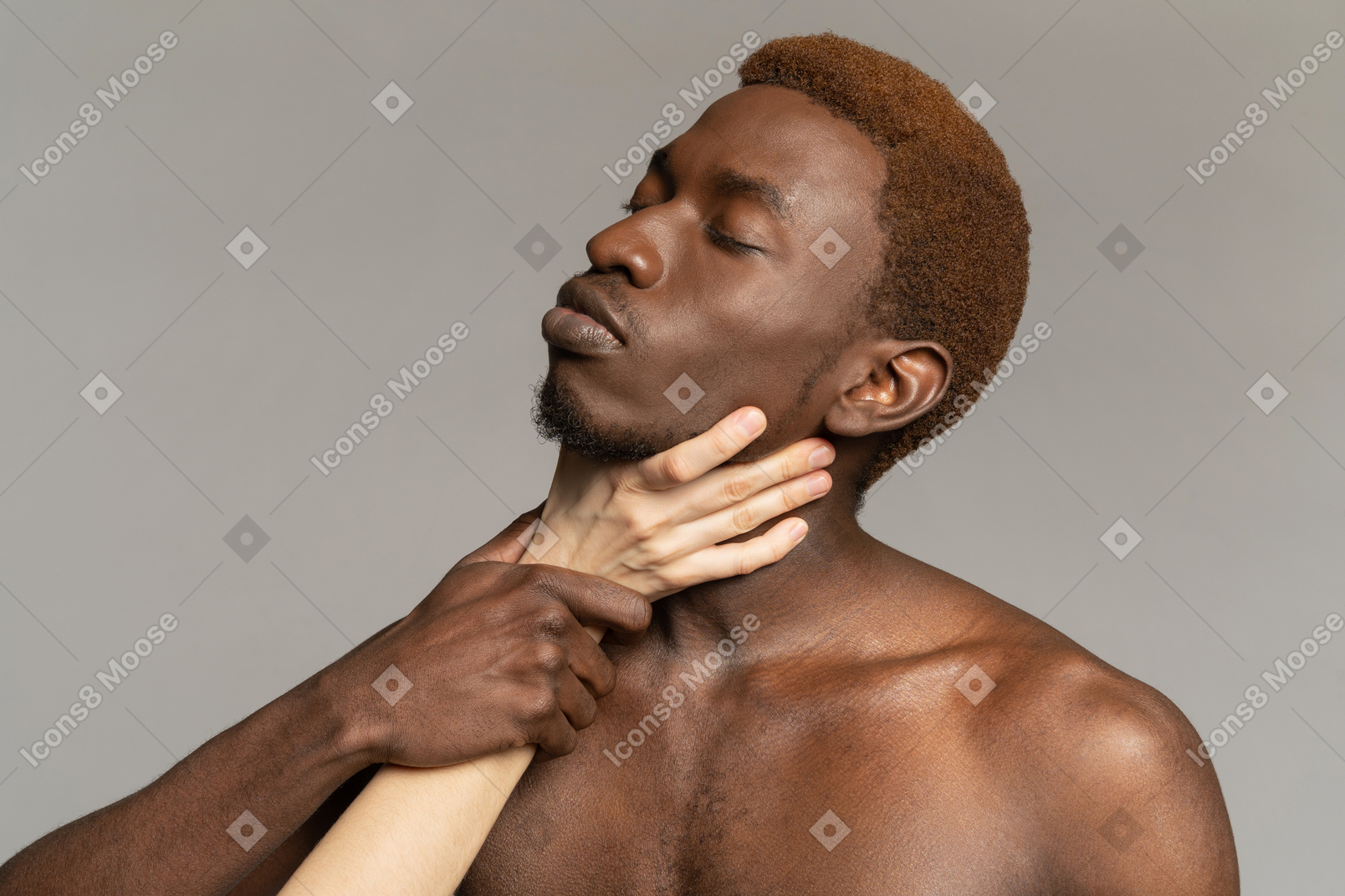 White hand holding neck of a young black man