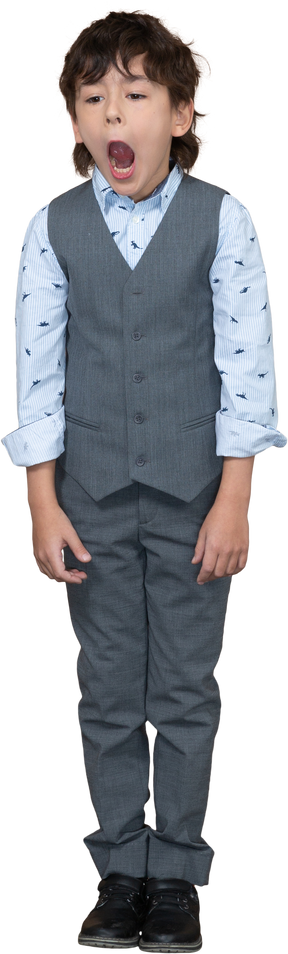 Front view of a boy in grey suit standing with open mouth
