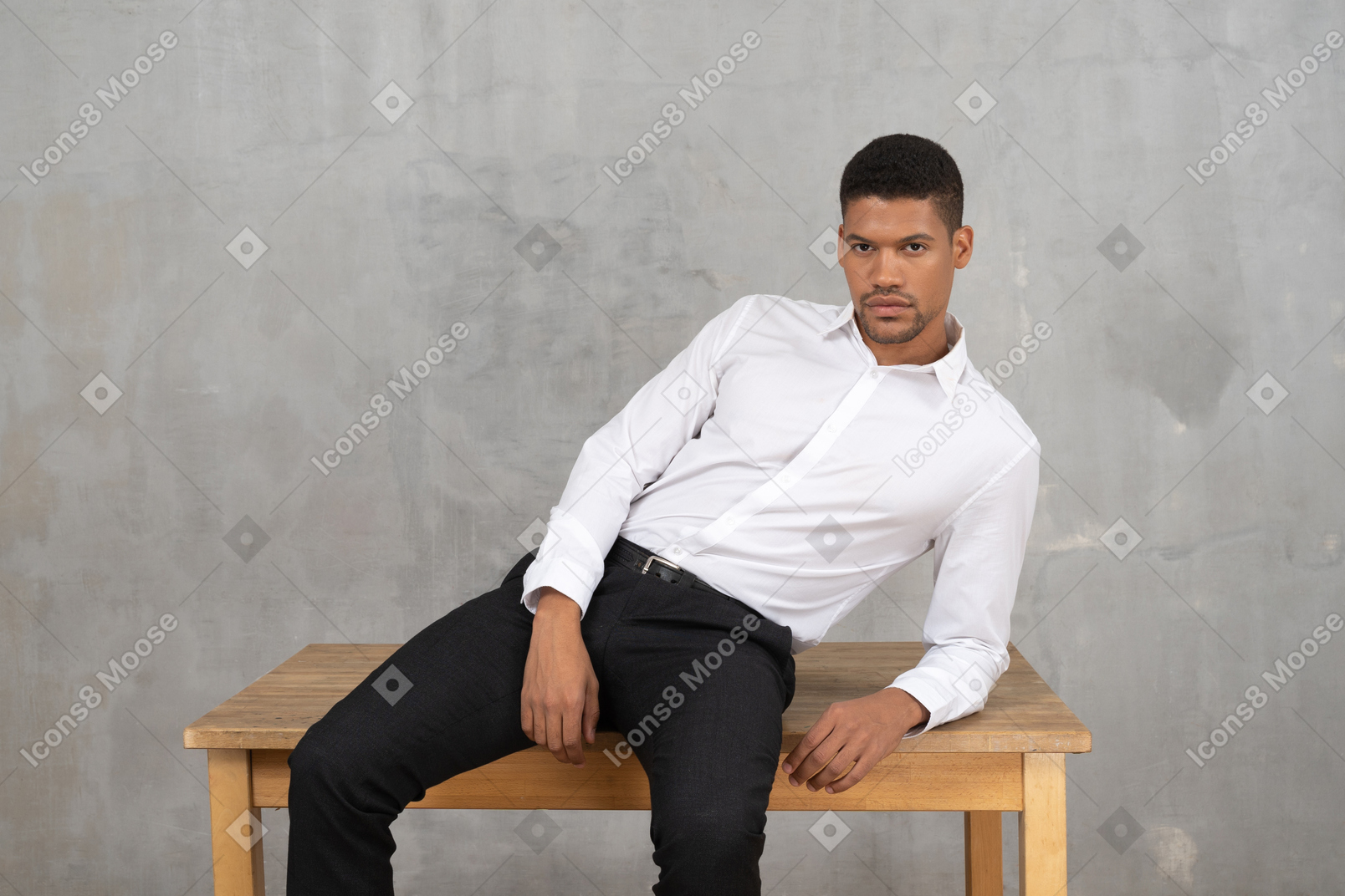 Relaxed man in office clothes sitting on a table