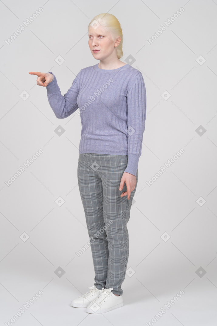 Serious young woman pointing straight