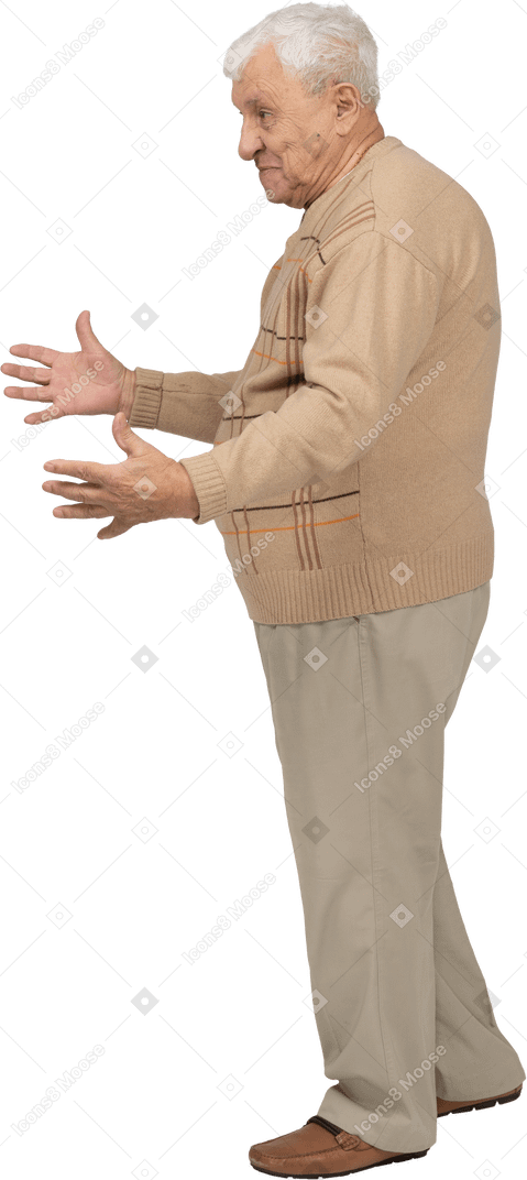 Side view of a happy old man in casual clothes standing with outstretched arms