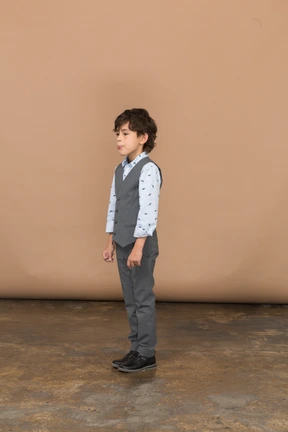 Side view of a cute boy in grey suit