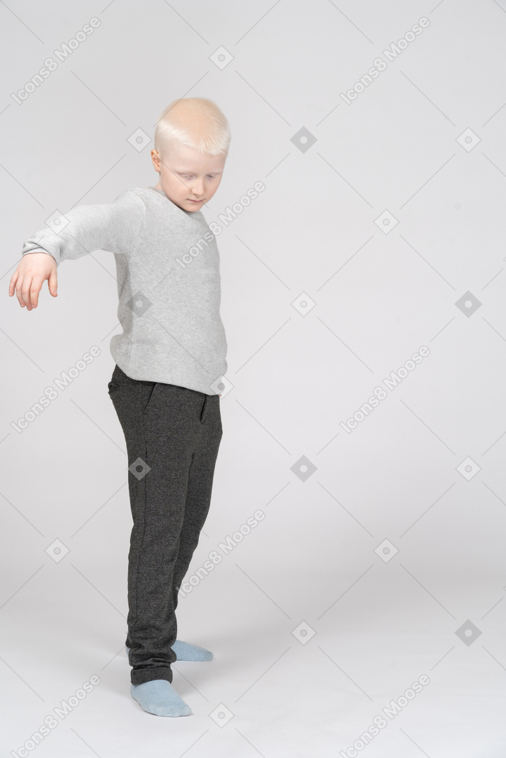 Vista lateral de um menino com a mão levantada