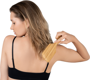 Vista traseira de uma jovem escovando o cabelo visão de uma jovem escovando o cabelo